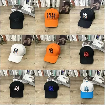 Nine baseball caps on a wooden shelf in black, white, orange and pale blue